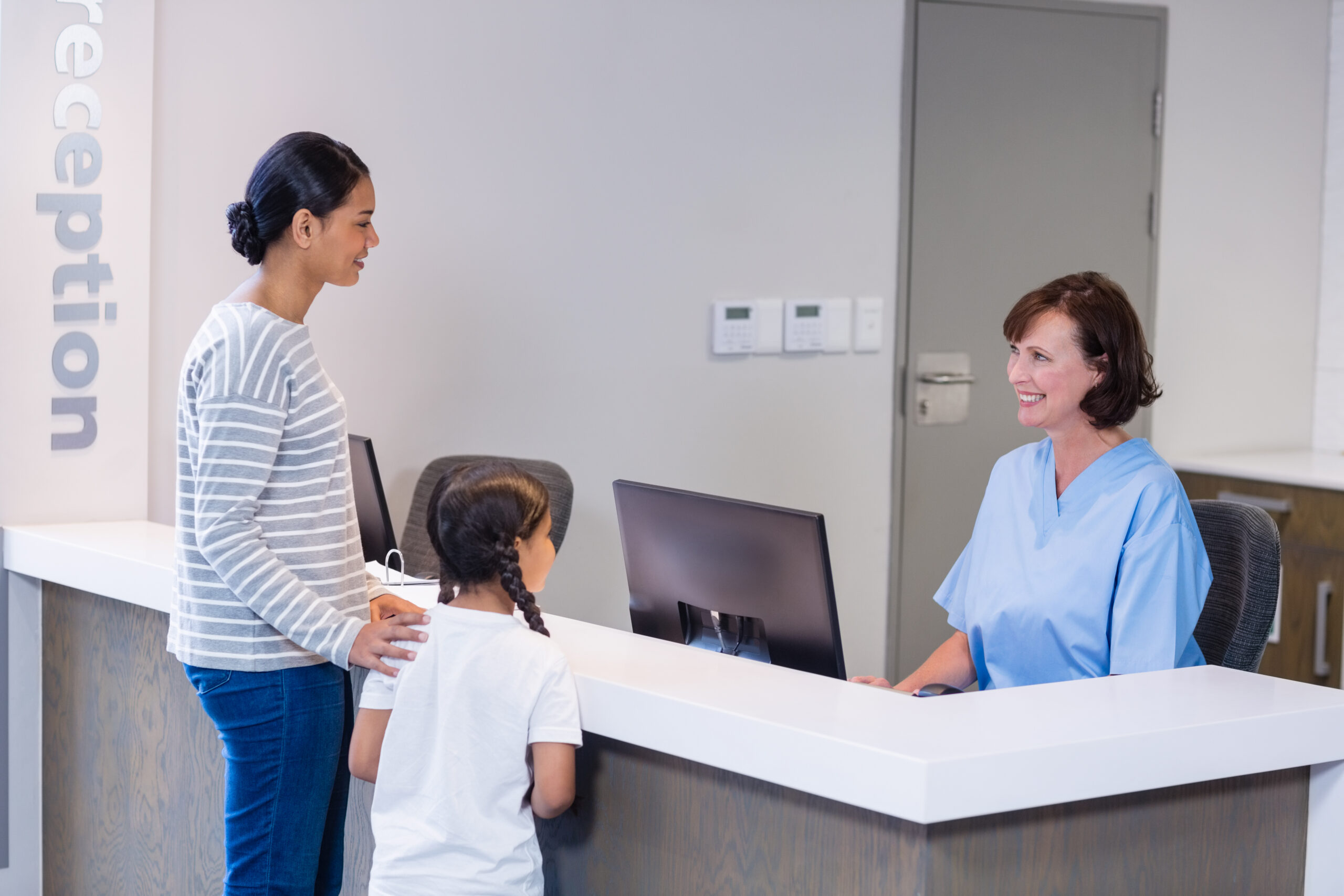 mother and child at reception desk in clinic 2026 03 25 06 04 27 utc 4 scaled